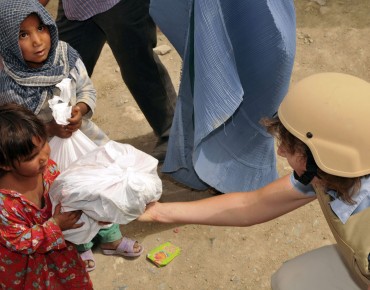KABUL, Afghanistan- An Afghan girl accepts a bag of supplies from a volunteer from the International Security Assistance Forces Headquarters at a Humanitarian Aid effort held at an Afghan Refugee Camp July 15, 2010. ( Photo by U.S. Air Force Senior Airman Tania Reid)