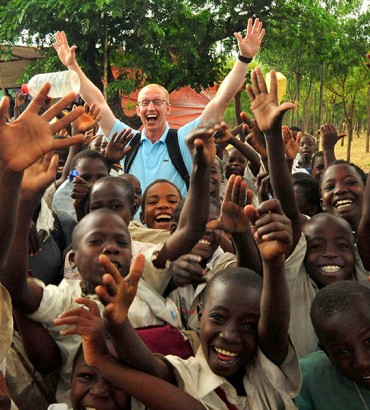 U.S. Air Force Senior Airman Daniel McKittrick, a public affairs broadcaster, assigned to Combined Task Force - Horn of Africa (CJTF-HOA), celebrates with children before a water project dedication ceremony in Magu, Tanzania, Jan. 21, 2008. The Magu water project provides clean drinking water to thousands of villagers in the Magu region of Tanzania and is a example of how CJTF-HOA develops and nurtures partnerships to promote regional cooperation and create an environment for development (U.S. Air Force photo by Staff Sgt. Joseph L. Swafford Jr./Released)